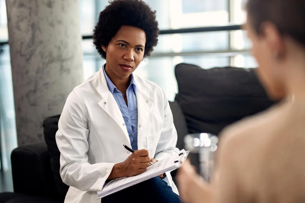 Mental health provider taking notes during a patient consultation