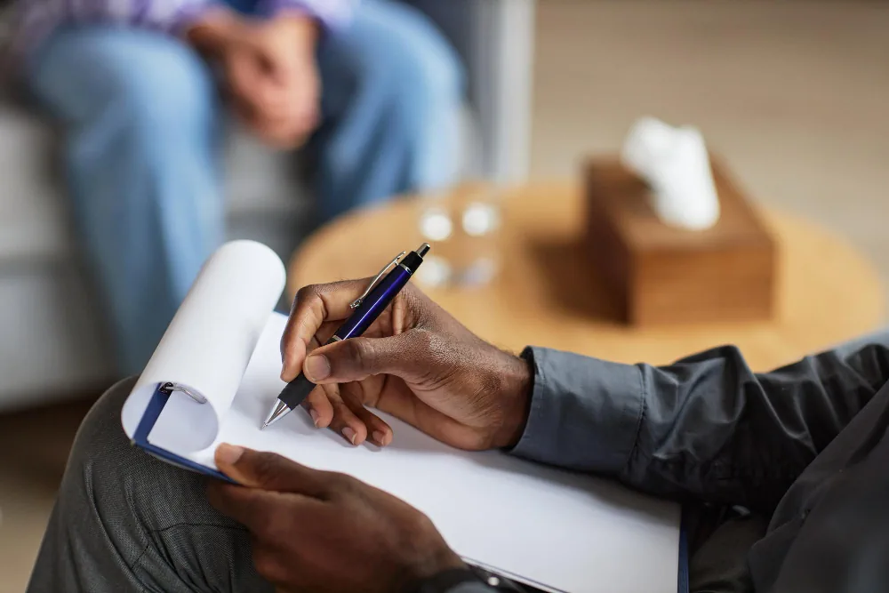 Clinician taking notes during a psychiatric evaluation